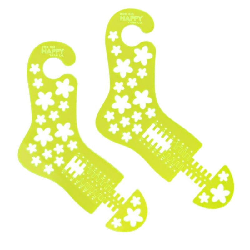 A bright neon yellow acrylic pair of sock blockers. The sock blockers have a hook at the top, flower cutouts to speed drying and an adjustable toe.