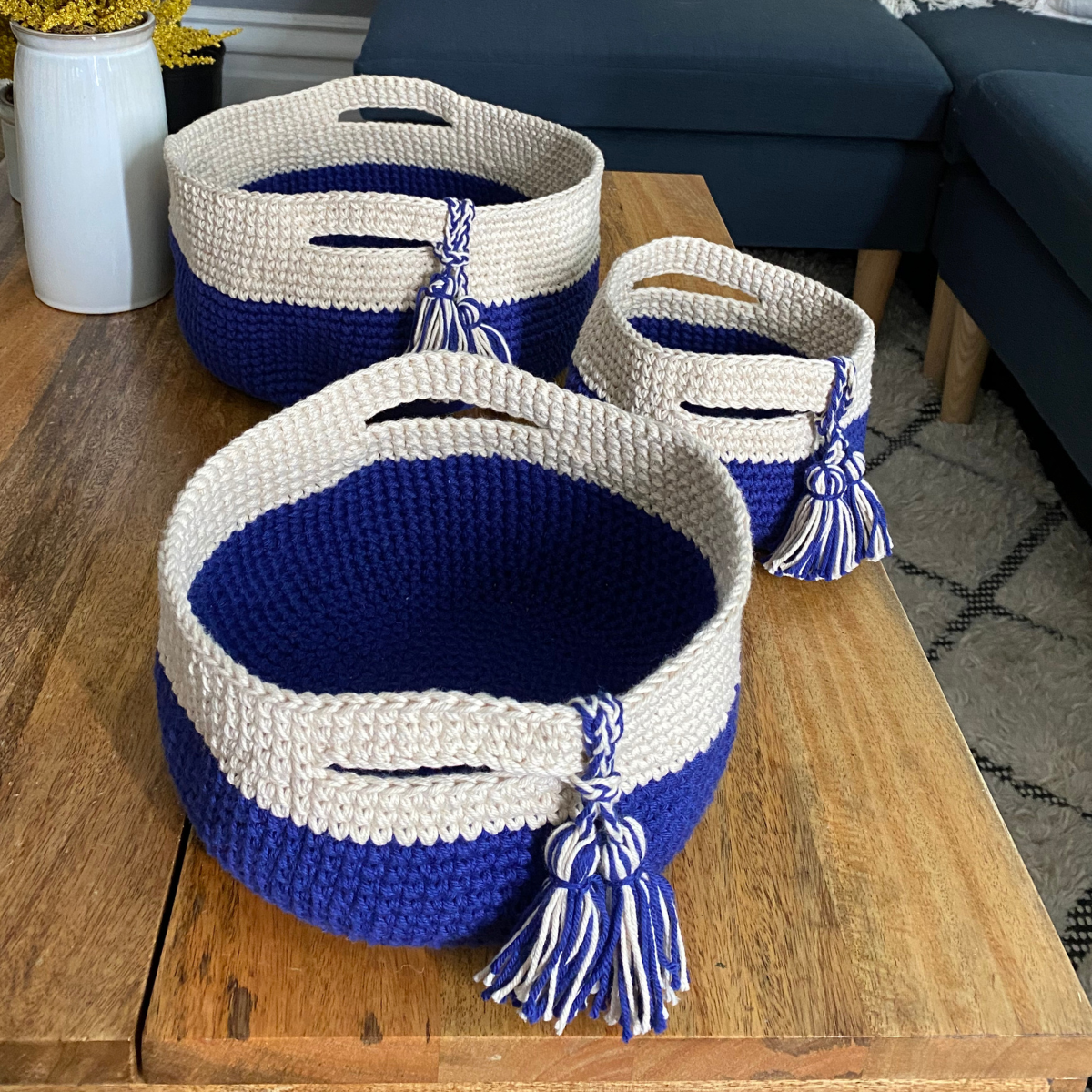 A set of three baskets crocheted from Cascade Yarns Nifty Cotton in Sapphire and Buff is shown.