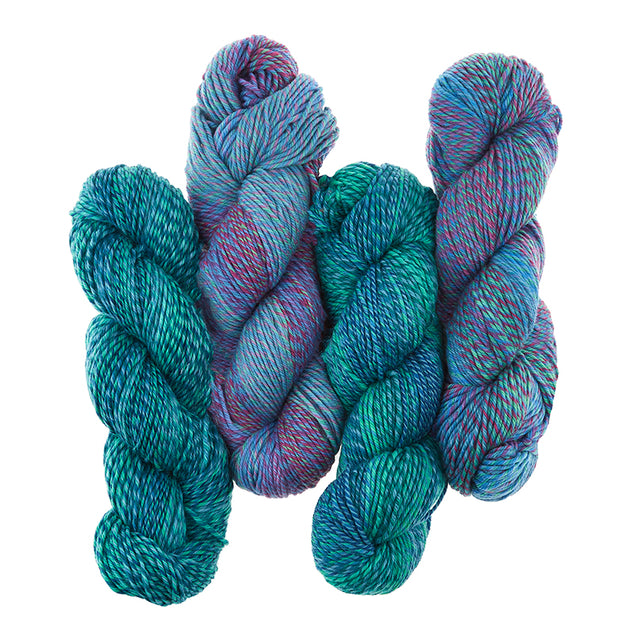 4 skeins of Cascade 220 Superwash Wave are shown in Blue Green (green) and Spring (Blue). he yarn is plied and has a long fading effect.