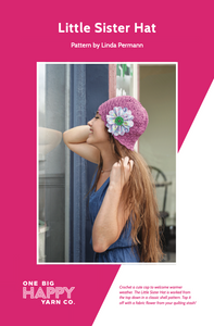A pattern cover shows a woman wearing a crocheted purple hat with blue fabric flower.