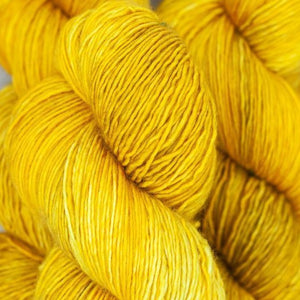 Skein of Madelinetosh Tosh Sock Sock weight yarn in the color Candlewick (Yellow) for knitting and crocheting.