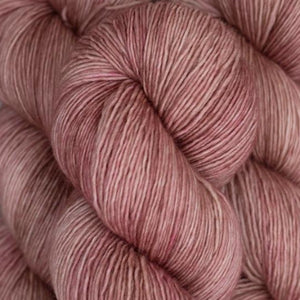 Skein of Madelinetosh Tosh Sock Sock weight yarn in the color Copper Pink Solid (Pink) for knitting and crocheting.