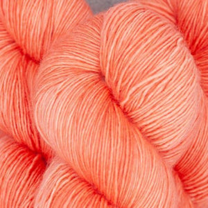 Skein of Madelinetosh Tosh Sock Sock weight yarn in the color Grapefruit (Orange) (orange)  for knitting and crocheting.