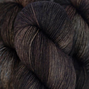 Skein of Madelinetosh Tosh Sock Sock weight yarn in the color Whiskey Barrel (Brown) for knitting and crocheting.