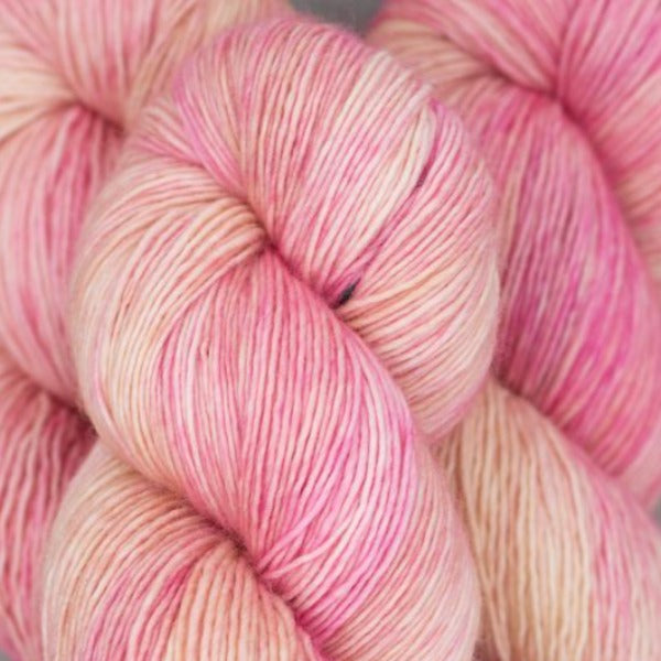 Skein of Madelinetosh Tosh Vintage Worsted weight yarn in the color Barbara Deserved Better (Pink) for knitting and crocheting.