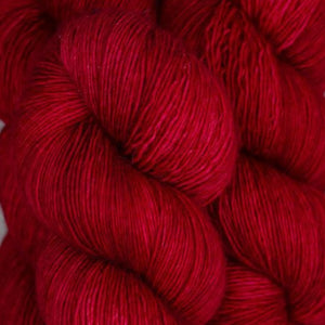 Skein of Madelinetosh Tosh Vintage Worsted weight yarn in the color Blood Runs Cold (Red) for knitting and crocheting.