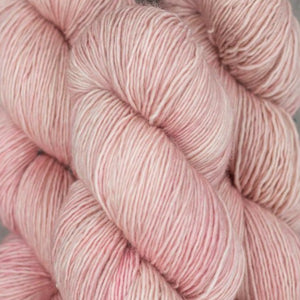 Skein of Madelinetosh Tosh Vintage Worsted weight yarn in the color Scout (Pink) for knitting and crocheting.