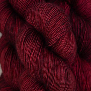 Skein of Madelinetosh Tosh Vintage Worsted weight yarn in the color Tart (Red) for knitting and crocheting.