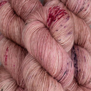 Skein of Madelinetosh Tosh Vintage Worsted weight yarn in the color Copper Pink (Pink) for knitting and crocheting.