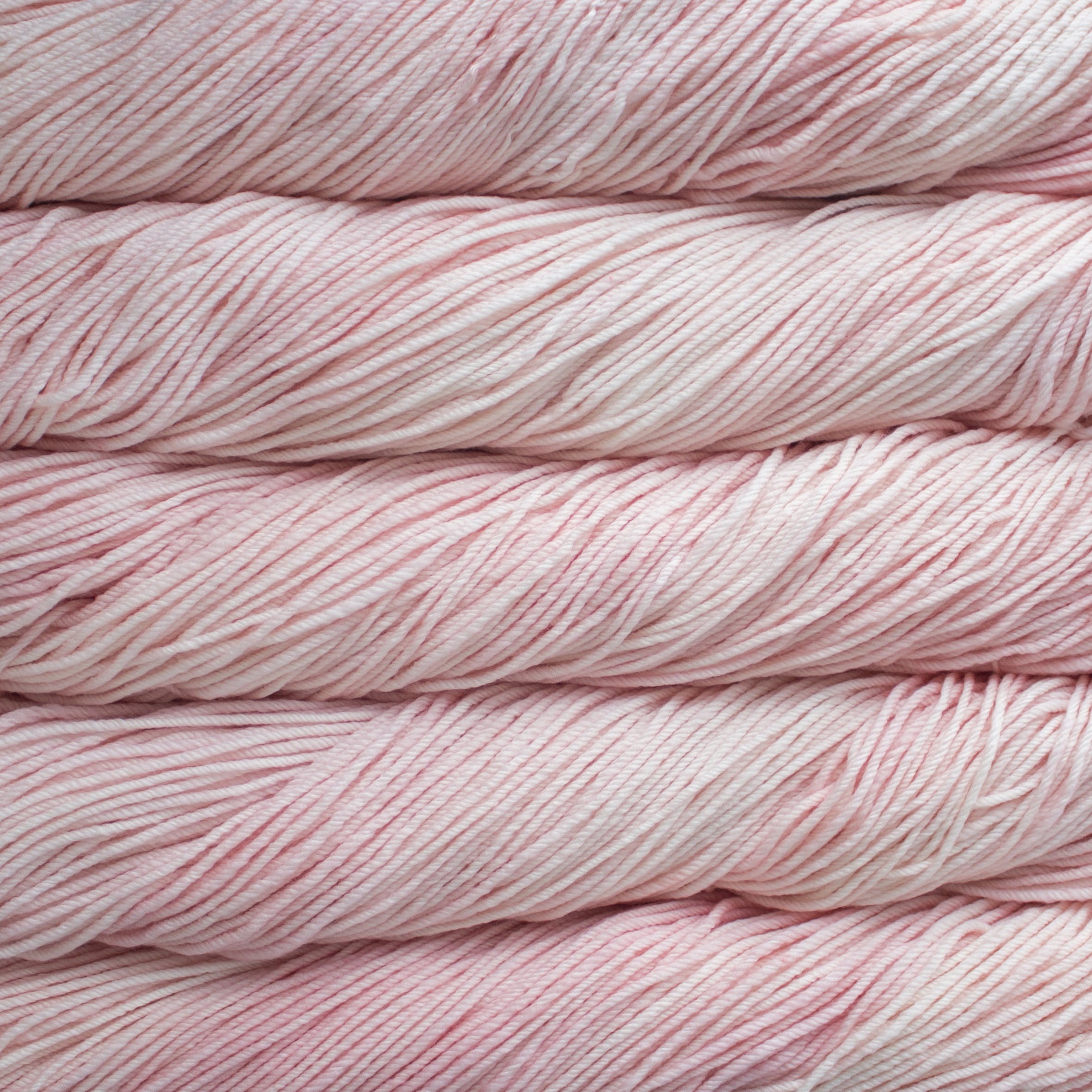 Skein of Malabrigo Rios Worsted weight yarn in the color Almond Blossom (Pink) for knitting and crocheting.