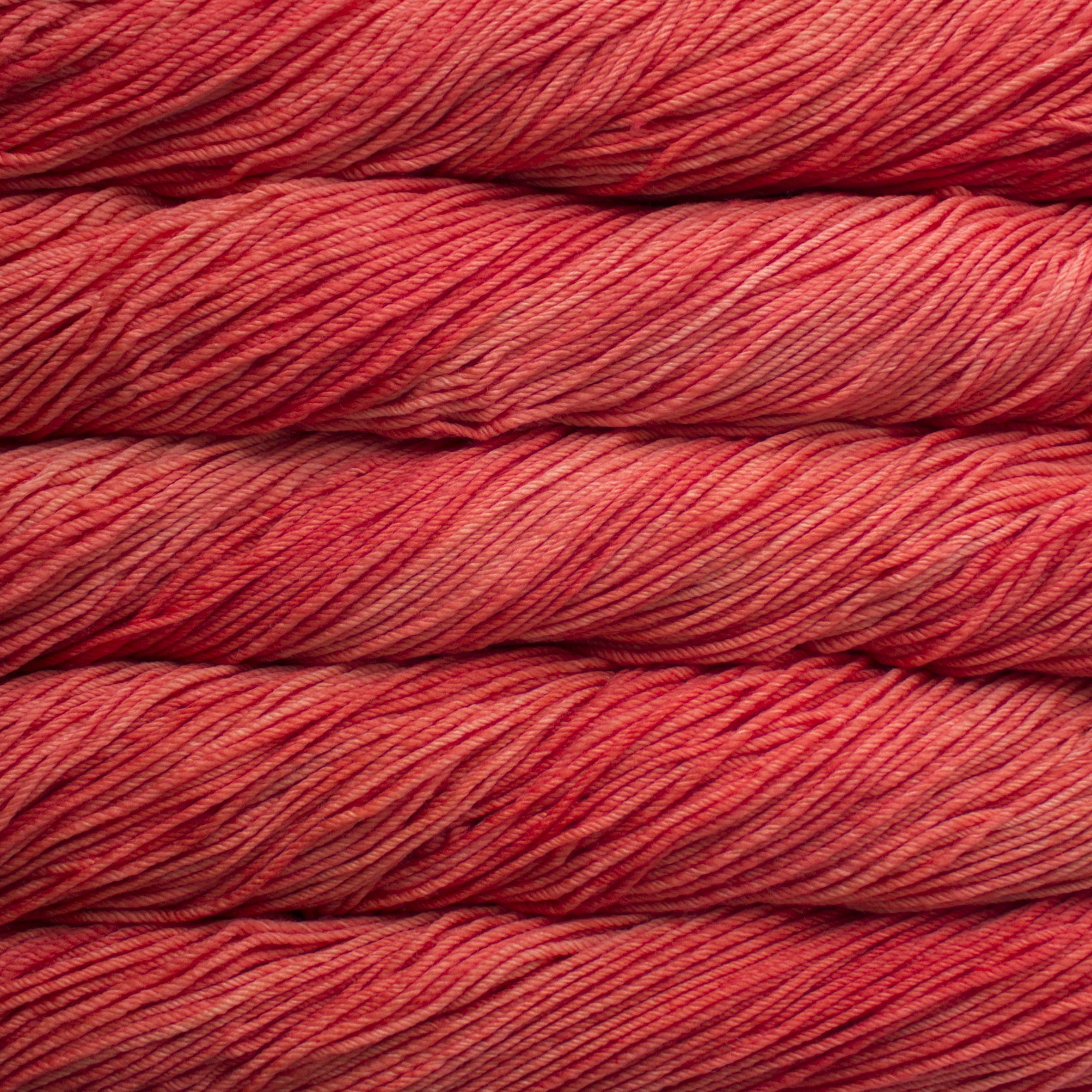 Skein of Malabrigo Rios Worsted weight yarn in the color Living Coral (Red) for knitting and crocheting.