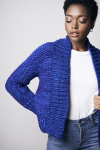 A woman models the Arya Cardigan, worked in a blue shade of Malabrigo Rasta.