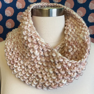 A pink textured seed stitch cowl is displayed on a natural colored dressform.