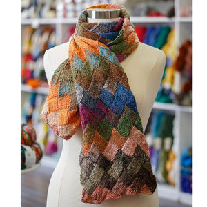 A beautiful entrelac scarf is shown draped on a dressform.