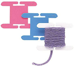 3 Clover brand knitting bobbins with yarn.